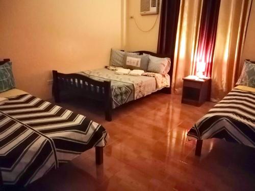 a living room with two beds and a couch at TGH Guest House Badian in Badian
