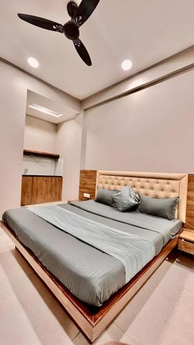 a bedroom with a large bed with a ceiling fan at Hotel Evanka in Indore