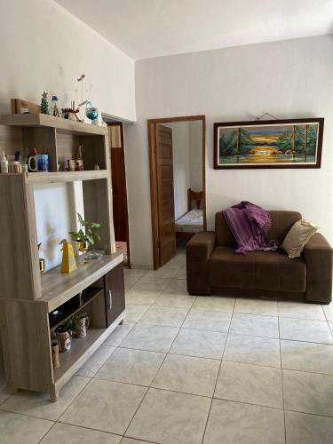 a living room with a brown couch in a room at Beleza e praticidade no bairro Mirante in Santa Cruz Cabrália