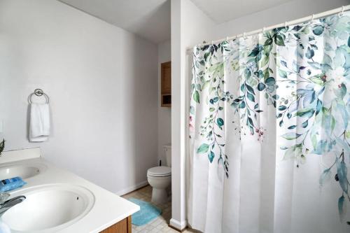 La salle de bains est pourvue d'un rideau de douche, d'un lavabo et de toilettes. dans l'établissement Modern Cottage Hot Tub River Access Fire Pit, à Luray