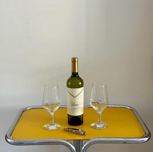 a bottle of wine and two glasses on a tray at Hermoso y Confortable Depto in Mendoza
