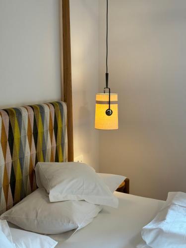 a bed with two pillows and a hanging lamp at Hotel Gartenresidence Zea Curtis in Merano