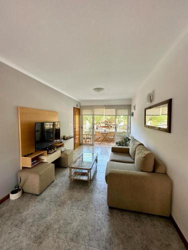een woonkamer met een bank en een tv bij Hermoso y Confortable Depto in Mendoza