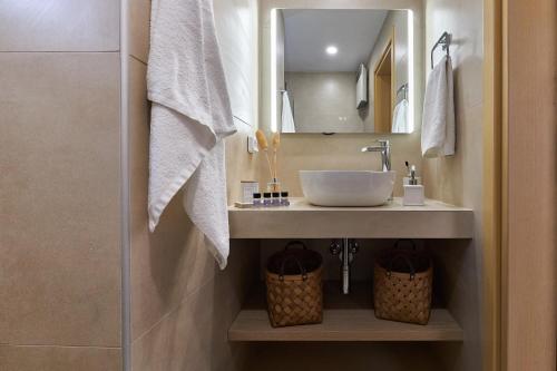 a bathroom with a sink and a mirror at Spacious villa with private eco-pool and panoramic sea view in Agia Pelagia