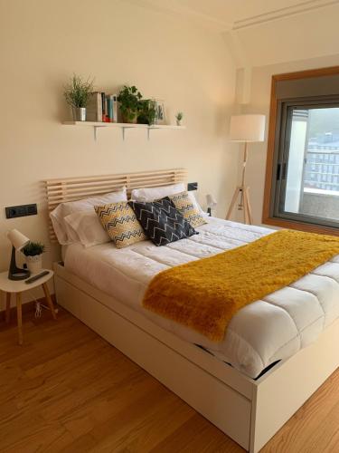 a large bed in a bedroom with a window at mi ático en plaza España in Ribeira