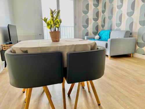 a table and chairs in a living room at Le Cocon central - Wifi - Transports et Commerces in Angoulême