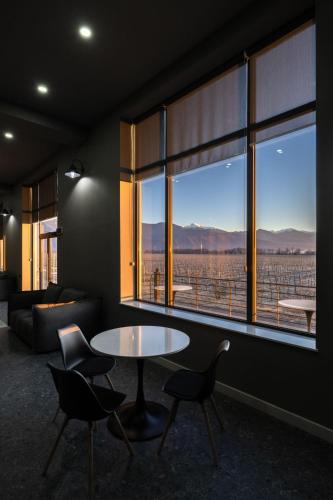 a living room with a table and chairs and a large window at Eclipse Winery Boutique Hotel in Kvareli