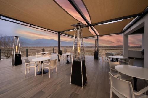 a restaurant with tables and chairs on a deck with a view at Eclipse Winery Boutique Hotel in Kvareli