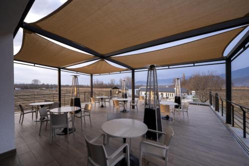 a pavilion with tables and chairs on a deck at Eclipse Winery Boutique Hotel in Kvareli