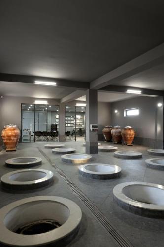 a museum with several large bowls on the floor at Eclipse Winery Boutique Hotel in Kvareli