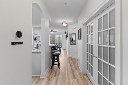 a hallway with white walls and wood floors and a stool at Havens #1123 condo in North Myrtle Beach