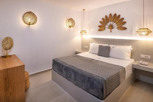a bedroom with a bed and a table and lights at Venus Sunrise Suites & Villas in Vourvoulos