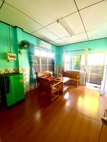 a living room with green walls and a table and chairs at สีชังสมายด์ in Ko Si Chang