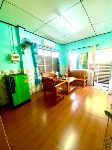 a living room with a table and a green tv at สีชังสมายด์ in Ko Si Chang