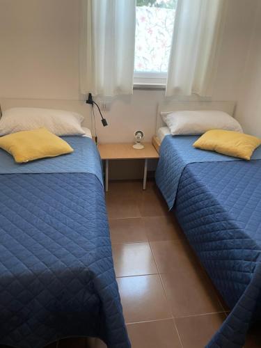 1 dormitorio con 2 camas y escritorio con ventana en Casa Rosa, en Mattinata
