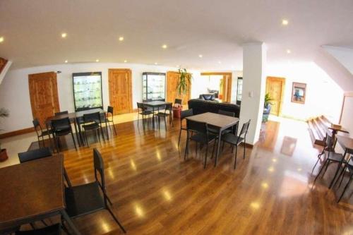 ein Wohnzimmer mit Holzböden, Tischen und Stühlen in der Unterkunft Hotel 5° Estación in Caldera