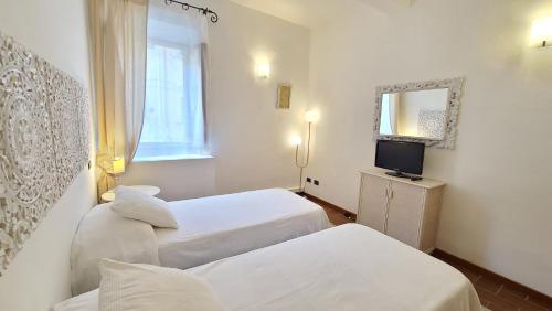 a hotel room with two beds and a television at Casa Calata in Portoferraio