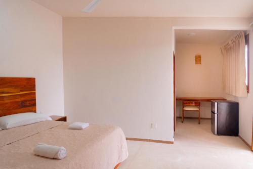 a white bedroom with a bed and a desk at Casa Victoria Puerto Escondido Beach in Brisas de Zicatela