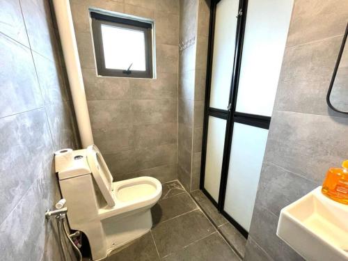 a bathroom with a toilet and a sink and a window at 4-10Pax The Subang Premium House - The Heart Of Subang in Subang Jaya