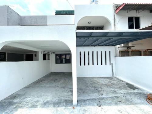 a white building with a garage and an open door at 4-10Pax The Subang Premium House - The Heart Of Subang in Subang Jaya
