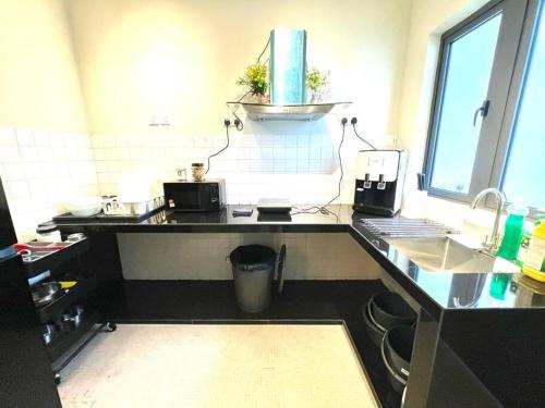 a kitchen with a black counter and a sink at 4-10Pax The Subang Premium House - The Heart Of Subang in Subang Jaya