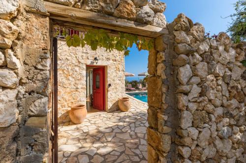 an entrance to a stone building with a red door at Villa Zoe (formerly Villa Eboros) in Ratzaklíon