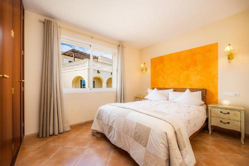 1 dormitorio con cama y ventana grande en Casa Colomba, en Cala Mendia