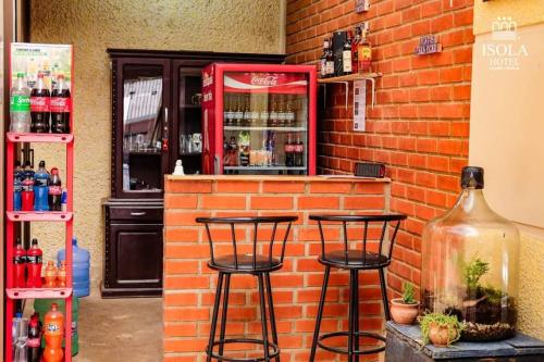 a bar with two stools in front of a brick wall at Hotel Isola in Aiquile