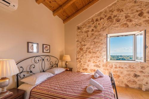 a bedroom with a bed in a room with a window at Villa Zoe (formerly Villa Eboros) in Ratzaklíon