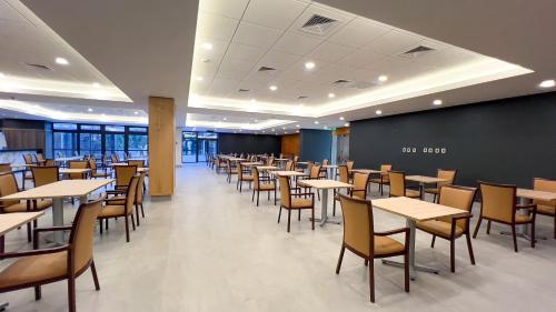 a dining room with tables and chairs at Hotel Diego de Almagro Pudahuel Aeropuerto in Santiago