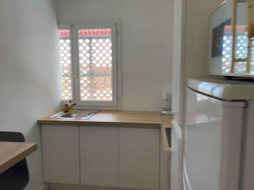 a small kitchen with a sink and a window at GITE PEI LA VANILLE "Studio Cosy en Bord de Nature" in Sainte-Suzanne