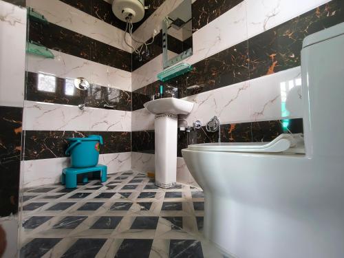 La salle de bains est pourvue d'un mur carrelé noir et blanc. dans l'établissement Valley Guest House Pahalgam, à Kolur