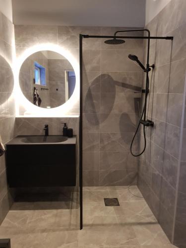 La salle de bains est pourvue d'une douche, d'un lavabo et d'un miroir. dans l'établissement Gäststuga, nära Piteå havsbad., à Piteå