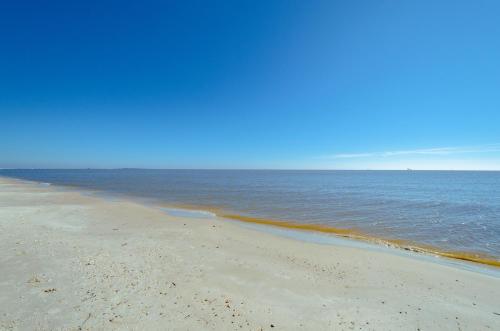 a sandy beach with the ocean in the background at Stylish Condo with a view of the water in Dauphin Island