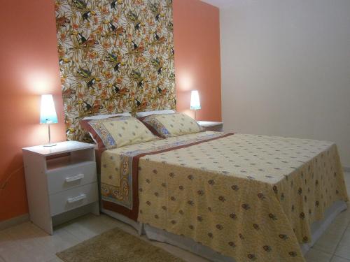 a bedroom with a bed with a large wall at Apt. de Setiba - HOSPEDARIA OCA RUCA in Guarapari