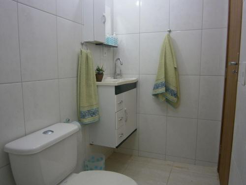 uma casa de banho com um WC e um lavatório em Apt. de Setiba - HOSPEDARIA OCA RUCA em Guarapari