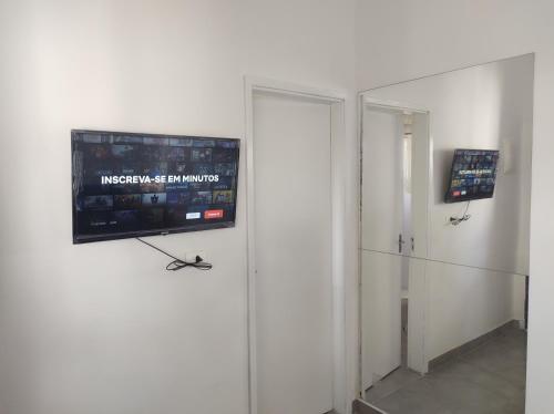 a room with a flat screen tv on a wall at Casa Cardoso in Bertioga