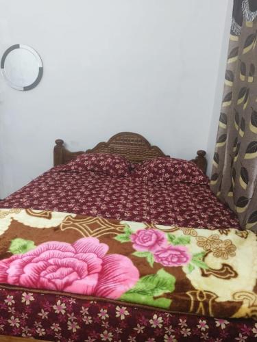 ein Bett mit einer Decke mit Blumen drauf in der Unterkunft Royal King Room's in Yercaud