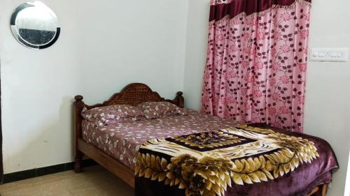 ein Schlafzimmer mit einem Bett und einem Vorhang in der Unterkunft Royal King Room's in Yercaud