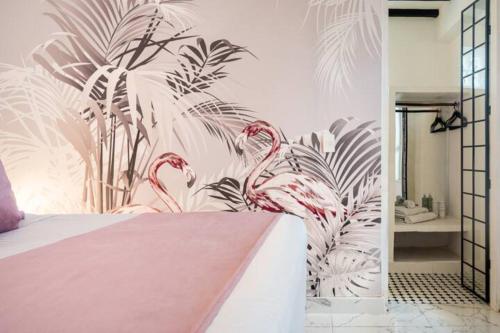 ein Schlafzimmer mit einem Wandbild von rosa Flamingos in der Unterkunft Casa Verde Hotel in Santa Marta