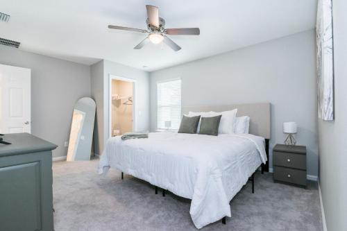 1 dormitorio con cama blanca y ventilador de techo en Brand New Luxury -King Bed- 15 min to attractions, en St. Augustine