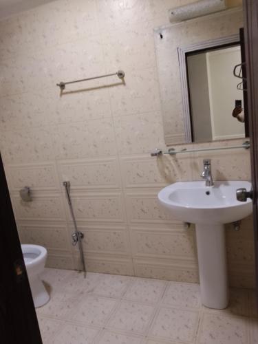 y baño con lavabo, espejo y aseo. en Rayan hight, en Islamabad