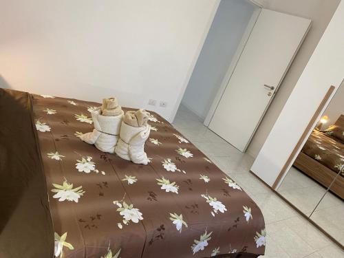 a bed with a brown comforter with white boots at Ale.Zelo Apartment in Zelo Buon Persico