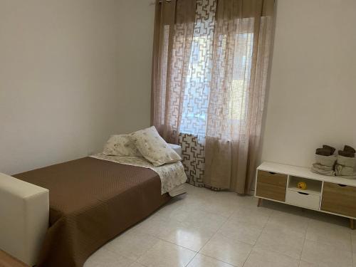 a bedroom with a bed and a dresser and a window at Ale.Zelo Apartment in Zelo Buon Persico