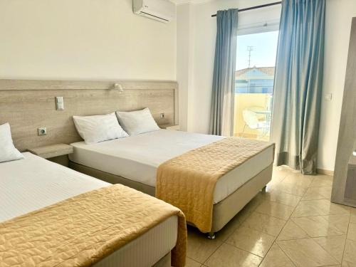 a hotel room with two beds and a balcony at Melis Studios in Kallithea Halkidikis