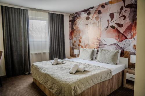 a bedroom with a large bed with two pillows on it at Plaza La - Night and Spa in Sremska Mitrovica