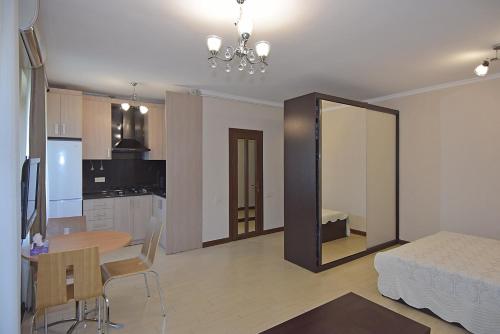 エレバンにあるLUX apartment on Koghbaciのベッド、テーブル、キッチンが備わる客室です。