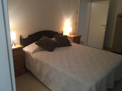 a bedroom with a large bed with two lamps on it at Modern apartment easy commute, Geneva & Nyon 75m2 in Founex