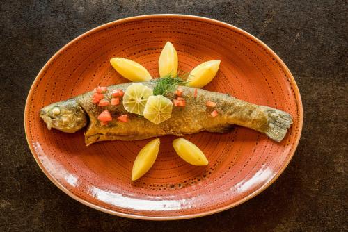 a plate of food with fish and vegetables on it at Best Western Plus Kurhotel an der Obermaintherme in Bad Staffelstein