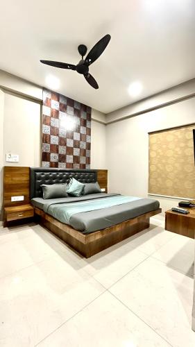 um quarto com uma cama e uma ventoinha de tecto em Hotel Evanka em Indore